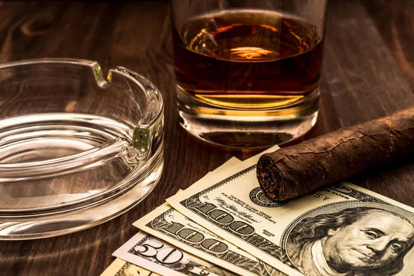 Bir bardak viski ve üzerinde Küba purosu olan bir para..