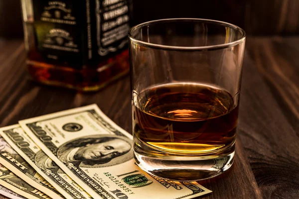 Ein Glas Whiskey Und Eine Flasche Mit Geld Auf Einem — Stockfoto