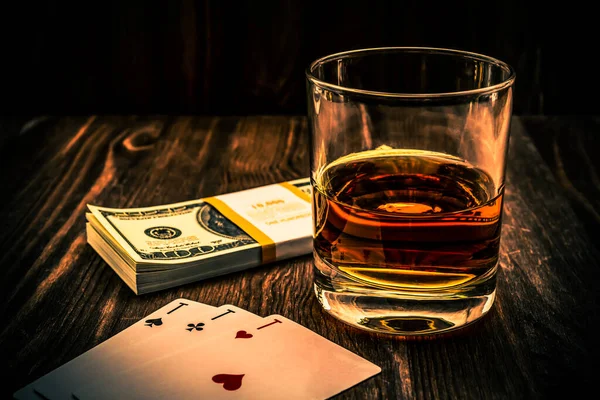 杯子里的威士忌和扑克牌 里面装着一包美元 — 图库照片