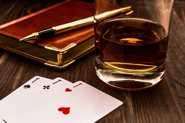 杯子里的威士忌和上面有皮革笔记本的扑克牌 — 图库照片