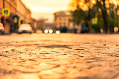 Central City meydanında gün batımı, arabaların farları...