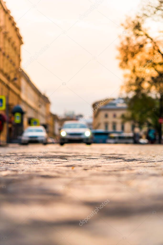 City street paved with stone, car traveling on the street. View 