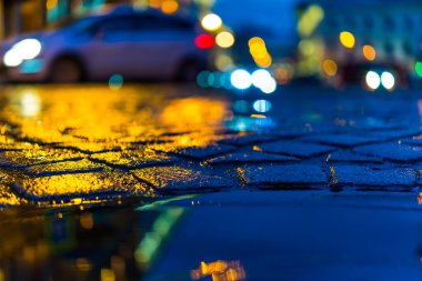 Akşam şehrin parlak ışıkları, yağmurdan sonra, farlar 