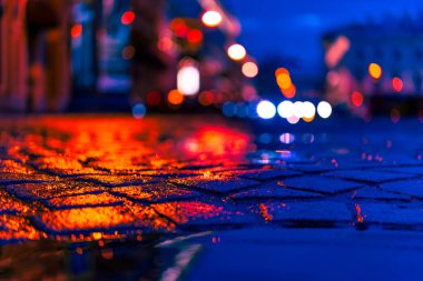 Akşam şehrin parlak ışıkları, yağmurdan sonra, farlar 