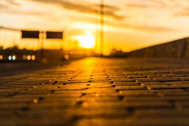 Şehrin rıhtımında gün batımı. Arabaların akışının görüntüsü