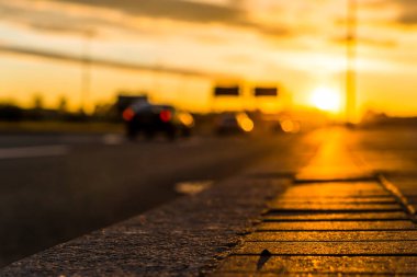 Şehrin rıhtımında gün batımı. Arabaların akışının görüntüsü