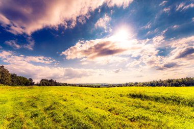 Güneş kümülüs bulutlarından çıkar ve tarlaları aydınlatır. 