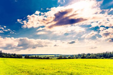 Güneş kümülüs bulutlarından çıkar ve tarlaları aydınlatır. 