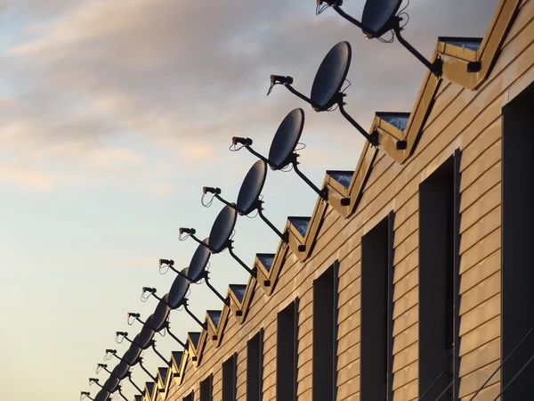 Satellite dishes row on building — Stock Photo, Image