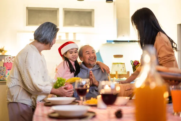Happy family time and relationship, Asian big family having small party eating food at home. Grandparent is happy to see his child and nephew eating food and drink wine together on dining table.