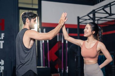 Spor takımından altı karın kası olan aktif sporcu erkek ve kadın sporcu spor salonunda, spor salonunda egzersiz yapmadan önce beşlik çakın ve fitness kulübünde güçlü ve kas geliştirin.