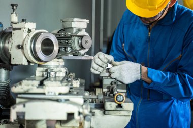 Asyalı çekici mekanik işçiler güvenlik için koruyucu gözlük ve kask takarlar. Fabrikada değirmen makinesinde çalışırlar. Endüstri teknisyeni. Çelik makinesinde kontrol ve kontrol.