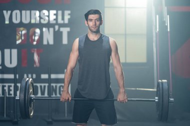 Spor salonunda kas ve pazılarını korumak için beyaz sporcu egzersizi. Stadyumdaki sağlık hizmetleri etkinliği için ağırlık kaldırarak ya da halter kaldırarak spor yapan aktif vücut geliştirici spor eğitmeni..