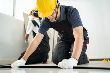 Asyalı zanaatkar işçiler evlerinde yere kaplama döşeme döşüyorlar. Çekici Joiner ve Carpenter kontrol ve sayım parke inşaatçı yardımcı olmak için bina veya ev yenilemek için onarım koridoru.