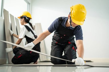 Asyalı zanaatkar işçiler evlerinde yere kaplama döşeme döşüyorlar. Çekici Joiner ve Carpenter kontrol ve sayım parke inşaatçı yardımcı olmak için bina veya ev yenilemek için onarım koridoru.