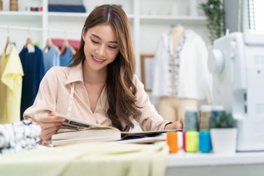 Genç bayan terzi ev ofisinde çalışıyor.