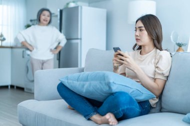 Asyalı kızgın, yetişkin bir kadın inatçı, mızmız kızına bağırıyor. Genç bayan kanepede oturur, cep telefonu sohbeti yapar, itaatsiz asi ve sinirli anneyi görmezden gelir. Ev kavramında aile sorunu.