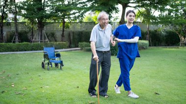 Bakım evindeki Asyalı genç kadın hemşire engelli yaşlı adama bakmalı ve destek olmalı.