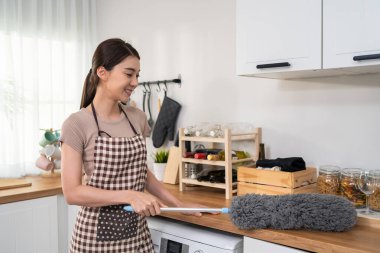 Kadın mutfak tezgahını toz alma aracıyla temizliyor