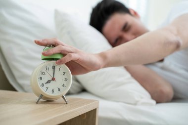 Yakışıklı erkek kendini tembel ve yorgun hisseder. Yatak odasında rahat bir yatakta uzanır. Gürültüyü duymazdan gelir ve uyanmak istemez.