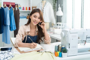 Genç bayan terzi ev ofisinde çalışıyor.