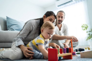 Aile yerde renkli oyuncaklarla oynuyor.