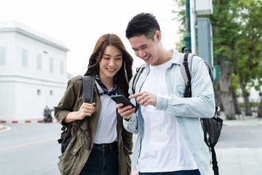 Akıllı telefonlara bakarken gülümseyen iki insan.