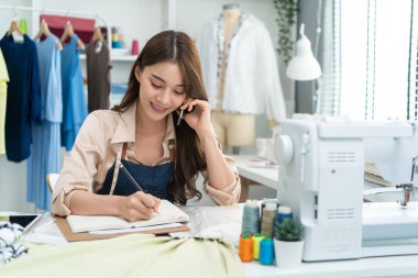 Genç bayan terzi ev ofisinde çalışıyor.