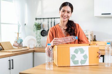 Mutfakta plastik şişeleri geri dönüşüm sırasında gülümseyen kadın.