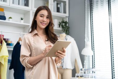 Genç bayan terzi ev ofisinde çalışıyor.