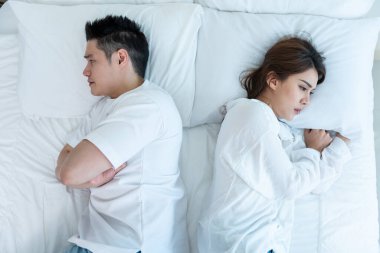 Asyalı genç bir çift kavga sonrası acı çekerek yatağa uzanıyor. Yeni evli erkek ve kadın kavga ettikleri için üzülüyor ve yatak odasında uyuyorlar. Aile sorunları ayrılığı kavramı.