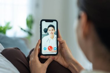 Doktorla görüntülü konuşma sırasında elinde akıllı telefon tutan kişi