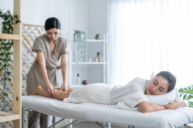 Asyalı genç kadın kendini mutlu hissediyor ve sırt masajı sırasında yağ ile rahatlıyor..