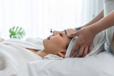 Kadın spa ortamında kafa masajı yaptırıyor.