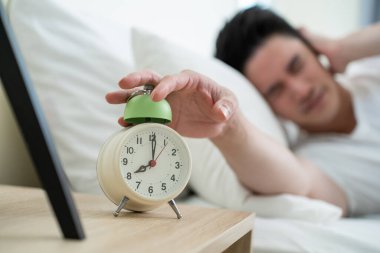 Yakışıklı erkek kendini tembel ve yorgun hisseder. Yatak odasında rahat bir yatakta uzanır. Gürültüyü duymazdan gelir ve uyanmak istemez.