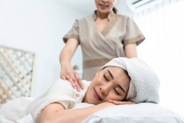 Asyalı genç mutlu kadın omuzlar ve sırt masajı sırasında rahatlıyor..