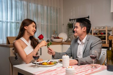 Romantik bir akşam yemeğinin keyfini çıkaran çift güler ve gülümser