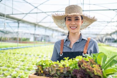 Serada taze sebzelerle gülümseyen bir kadın.
