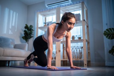 Genç ve çekici Asyalı kadın evde egzersiz yapıyor.