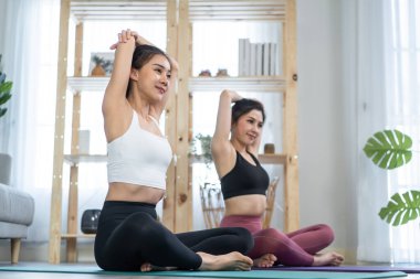 Asyalı aktif kadın arkadaşlar evde birlikte Yoga pilates yapıyorlar..