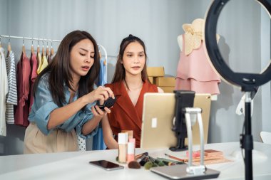 Video dersi kaydederken makyaj yapan iki kadın