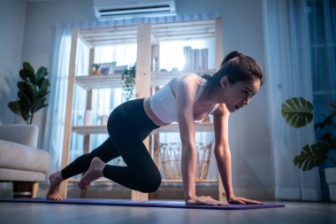 Genç ve çekici Asyalı kadın evde egzersiz yapıyor.