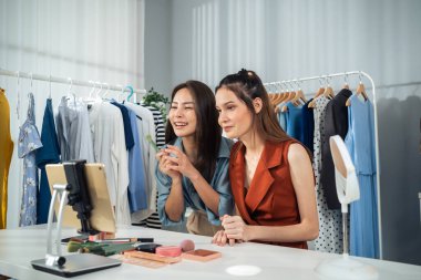 Giyim mağazasında tablet kullanırken gülümseyen iki kadın