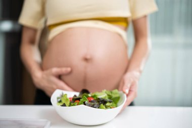 Genç Asyalı hamile kadın evdeki mutfakta.