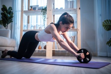 Genç ve çekici Asyalı kadın evde egzersiz yapıyor.