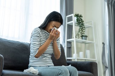 Kanepede oturan bir kadın peçete tutarken ağlıyor.