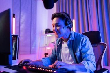 Genç Asyalı oyuncu bilgisayarla oyun oynuyor