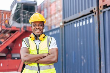 Genç Afrikalı Amerikalı işçilerin portresi konteynır terminalinde çalışıyor. İthalat ihracat için kargo gemisindeki depo lojistiğinde planlamaları için çekici erkek işçiler ve ürünler..
