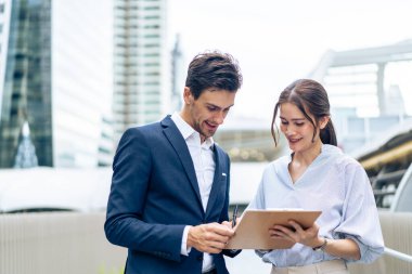 Kafkas işadamı ve Asyalı kadın işçiler şehirde dışarı çıkıyorlar. Çekici genç erkek ve kadın çalışanlar ofis şirketine yürürken bir proje hakkında konuşup fikir alışverişinde bulunuyorlar..