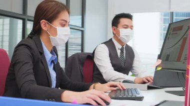 Modern ofiste masalarında oturan profesyonel ofis çalışanları.